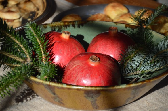 A last-minute centerpiece: pomegranates and Christmas tree trimmings in a bowl.