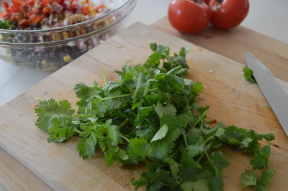 Twist off the root ends of a cilantro bunch. (Stems are OK, though.) Wash and spin as if it were lettuce. Chop the leaves and stems. 